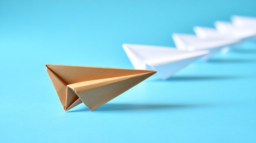 Brown Paper Plane Leading White Ones on Blue Background