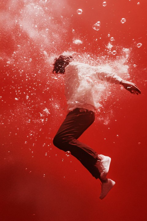 Escaping Figure from an Exploding Bubble on Red Background