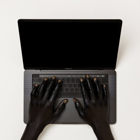 Black Hands on Laptop Keyboard, Top View with White Background